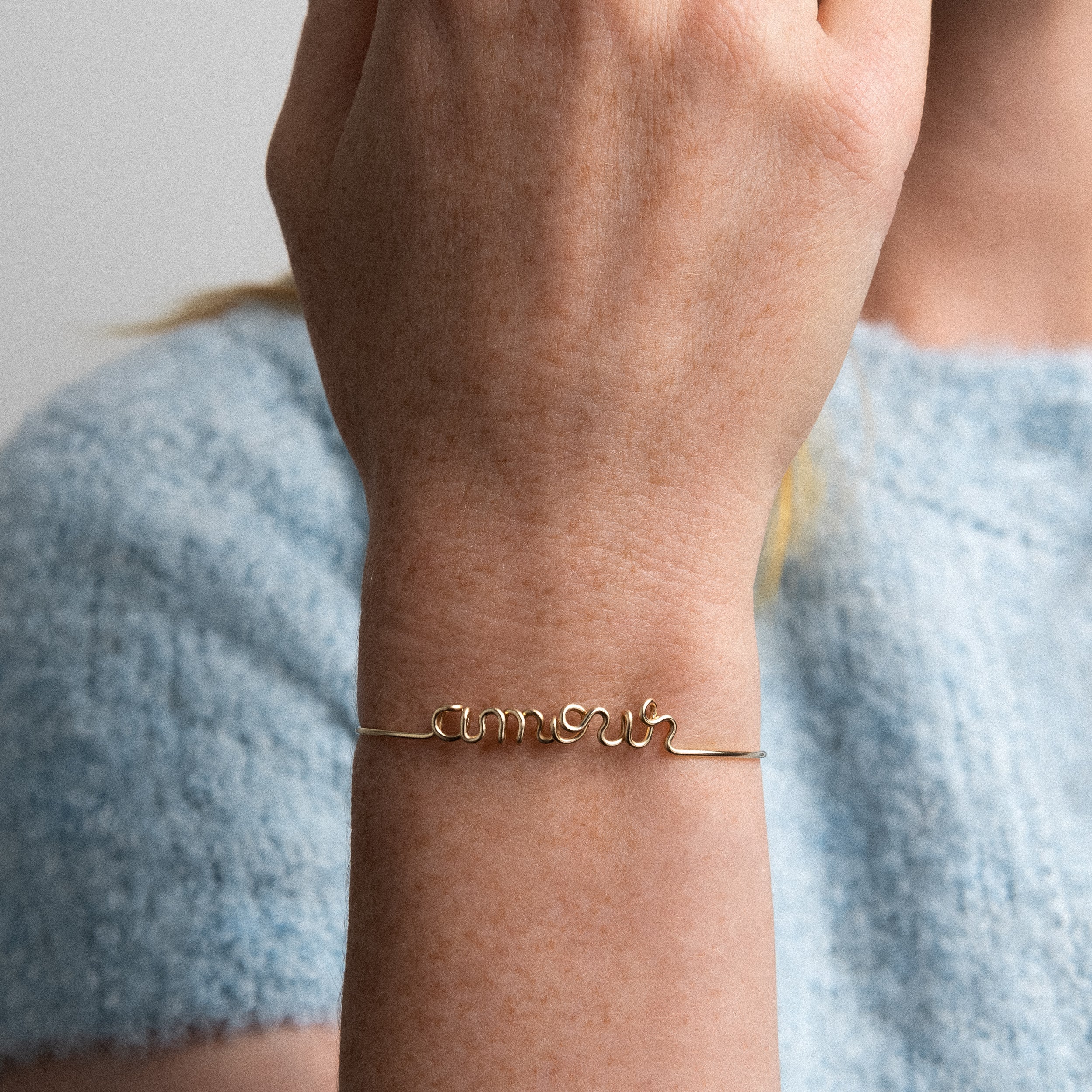 Original bracelet with word Amour yellow gold-filled worn on finger handcrafted Atelier Paulin Australia