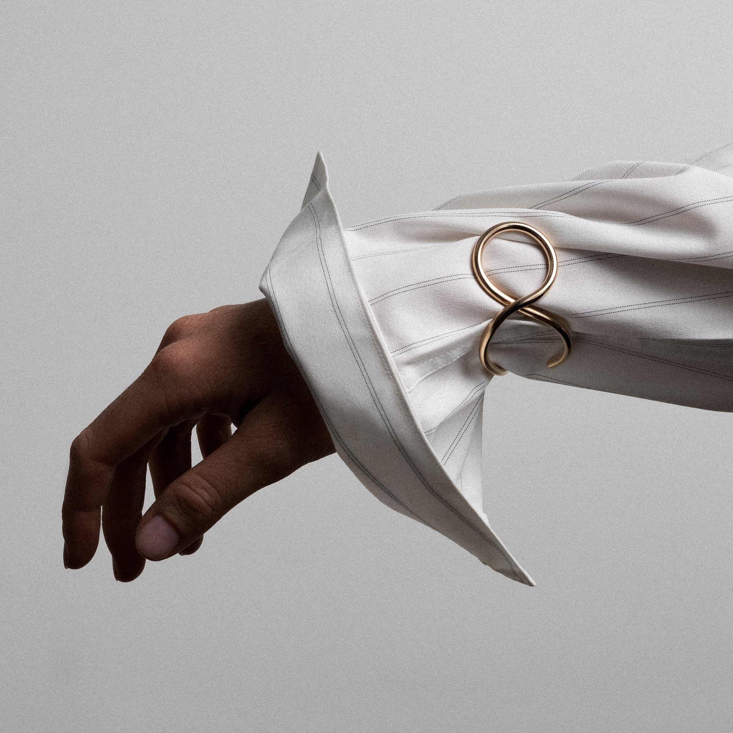 Outline cuff bracelet letter v yellow gold worn over shirt sleeve accessory Atelier Paulin Australia
