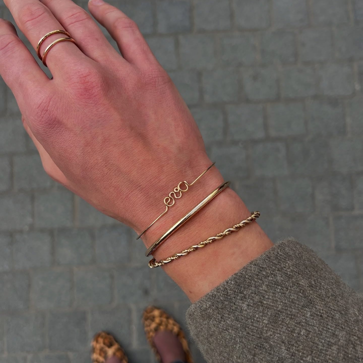 woman wearing bracelets stack and personalised gold bracelet with eva name