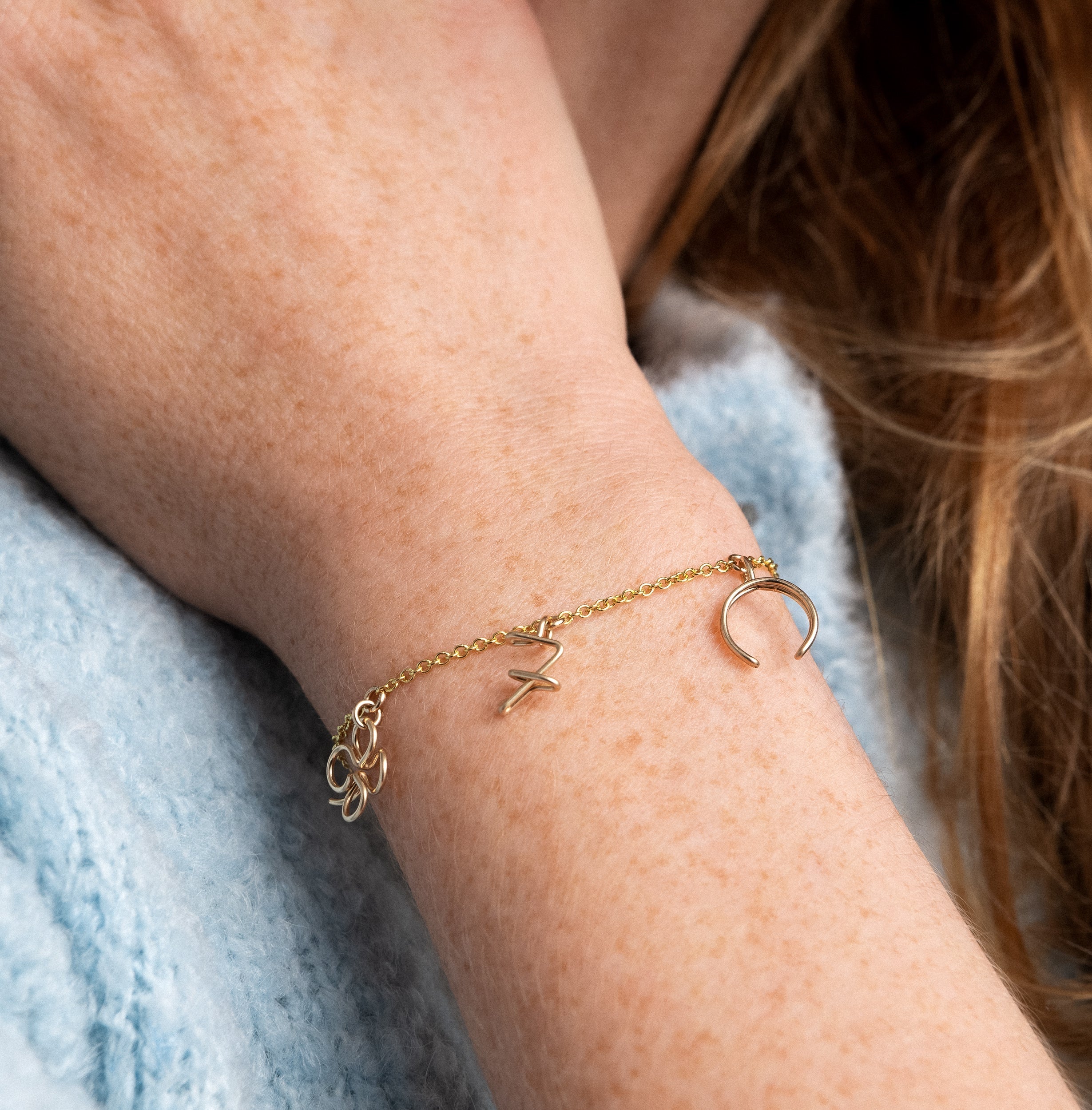 Wish Me Luck charms bracelet on chain yellow gold worn on wrist handcrafted Atelier Paulin Australia