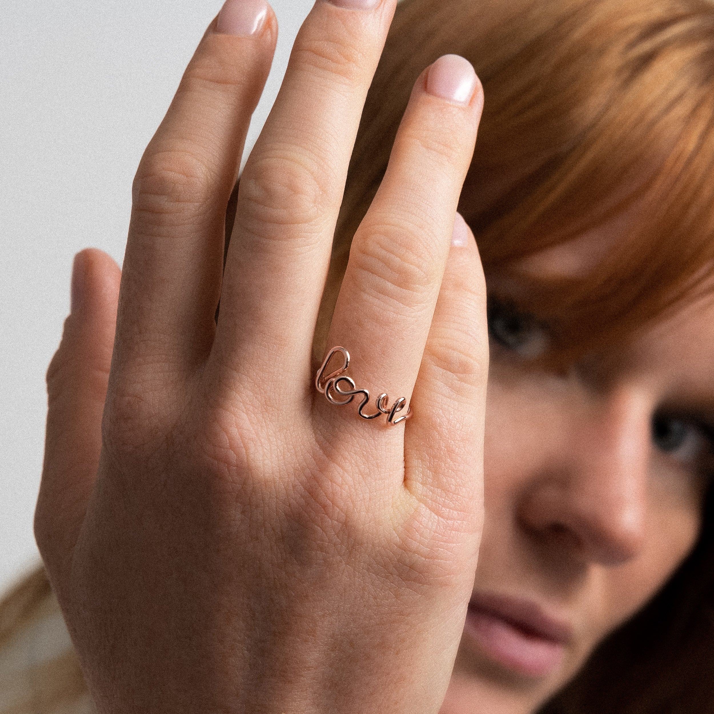 Original ring word Love rose gold worn on finger handmade in France Atelier Paulin Australia