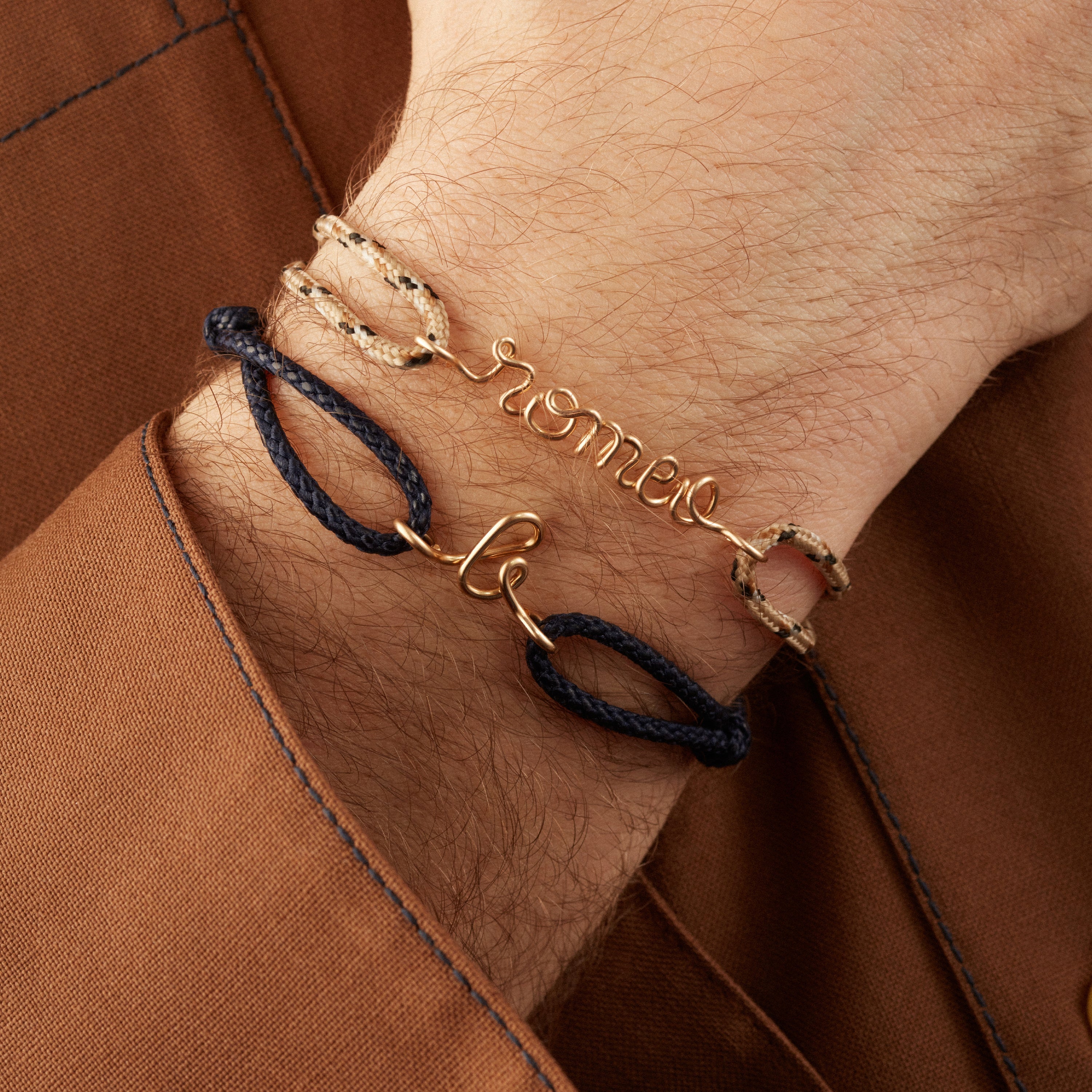 Gold jewellery bracelet set on a navy blue cord on a man's wrist - Atelier Paulin