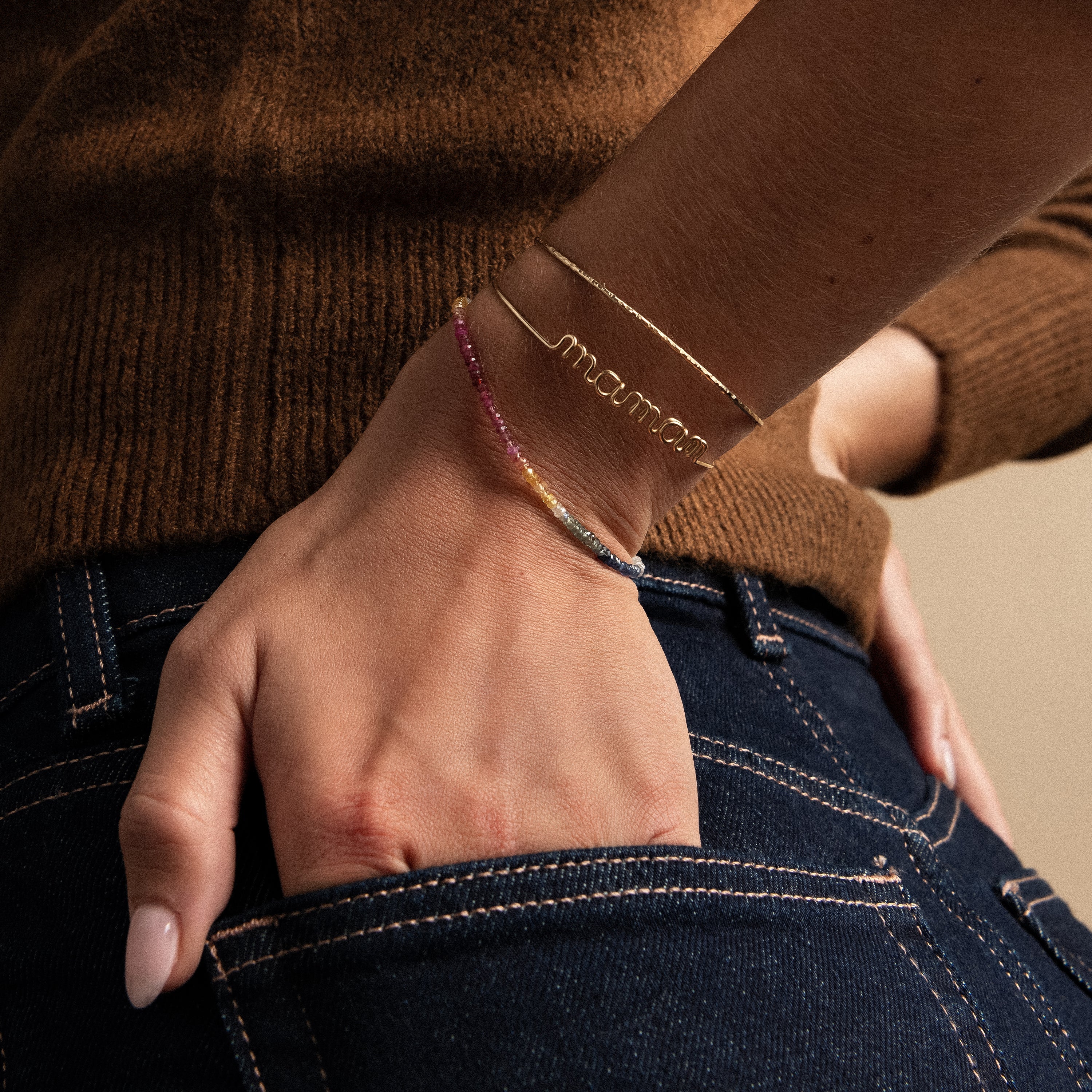 Original wire bracelet word maman yellow gold worn on wrist in denim pocket Atelier Paulin