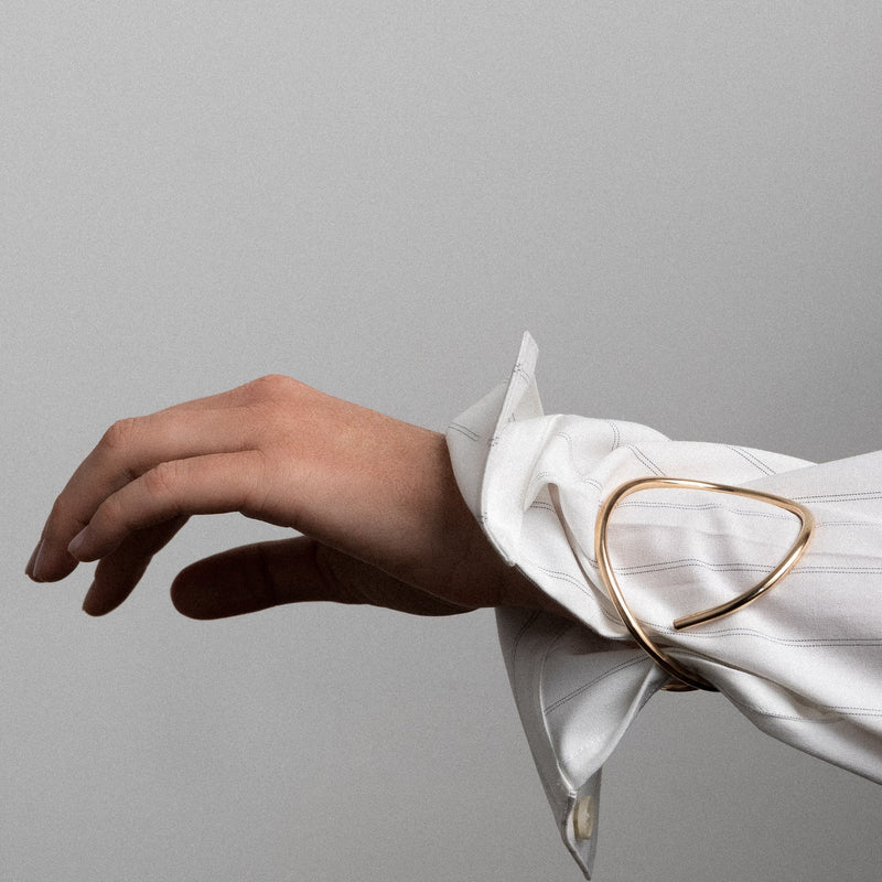 Outline cuff letter o yellow gold worn over shirt sleeve handmade in Paris Atelier Paulin Australia